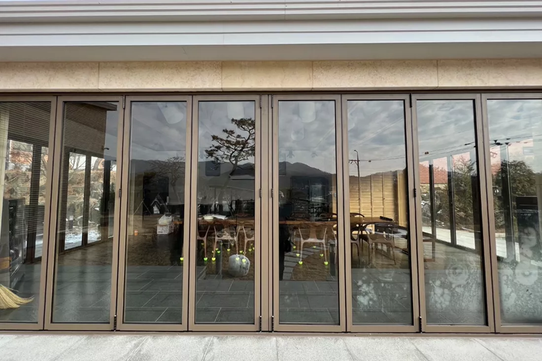 시공 전 폴딩도어 — 투명한 유리로 실내가 훤히 비치는 모습