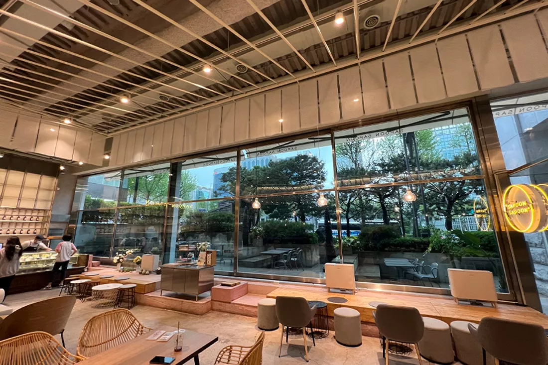 통유리 안쪽에서 바라본 야외 테라스와 조경, 시공 전 매장 전면 유리 전경