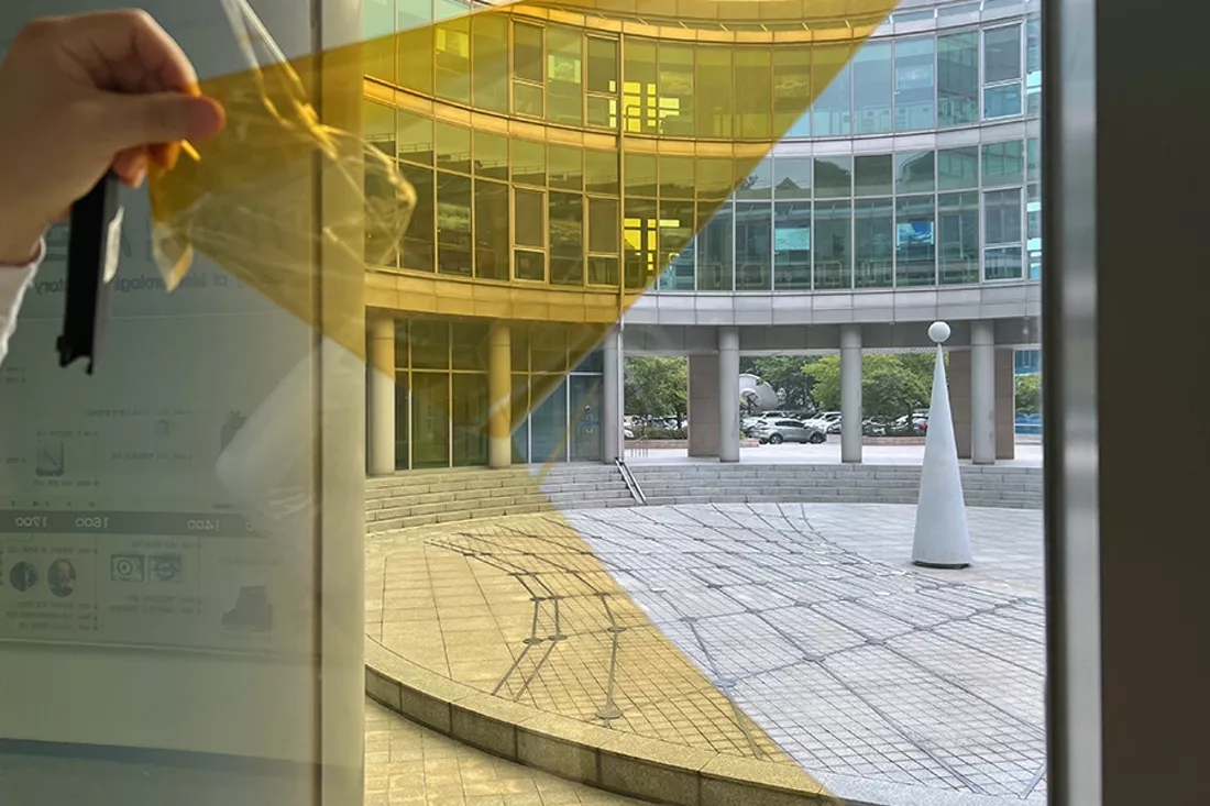 필름 보호 코팅지를 떼어내며 시공 전후 유리 색감을 비교하는 모습