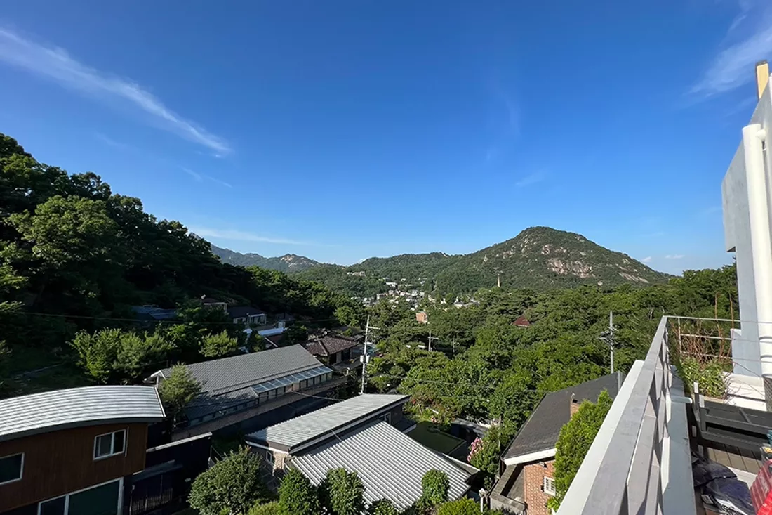 필름 시공이 완료된 테라스 유리와 산 능선 조망