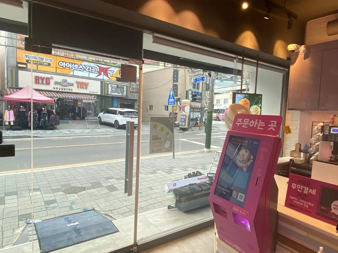 매장 내부 카운터와 유리창 너머로 보이는 도로 전경