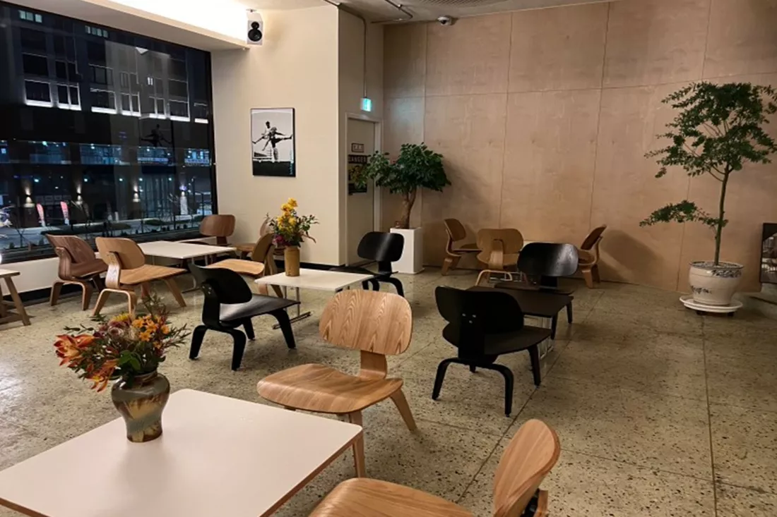 필름 시공이 끝난 통유리 창가 좌석, 야간 도심 전망이 은은하게 비치는 모습