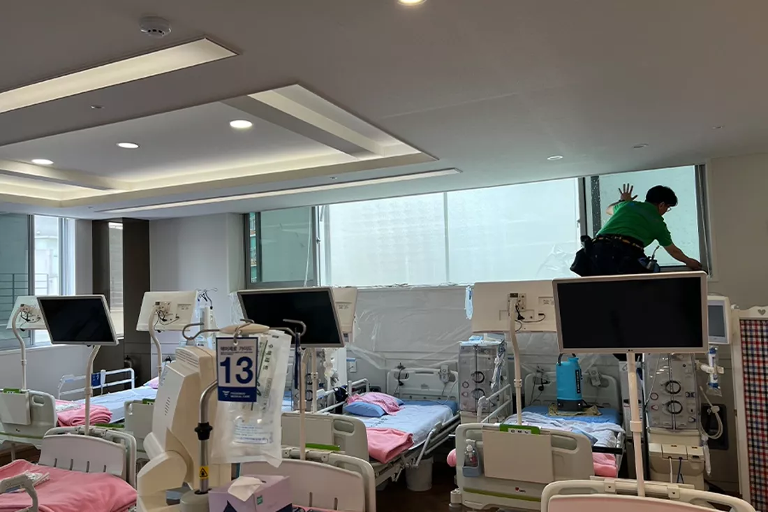 기사가 처치실 상단 창에 열차단 필름을 부착하는 작업 모습